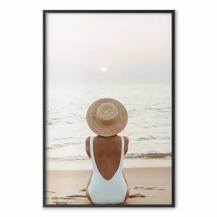 Strandvila - kvinna sitter på sanden och njuter av solnedgången