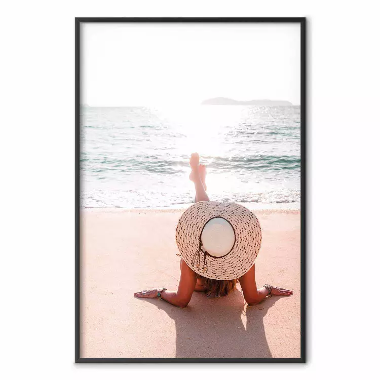 Strand - kvinna i hatt ligger på stranden med havsutsikt
