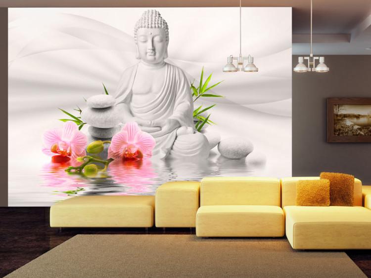 Fototapet Bright Buddha - Buddhafigur med två orkidéblommor