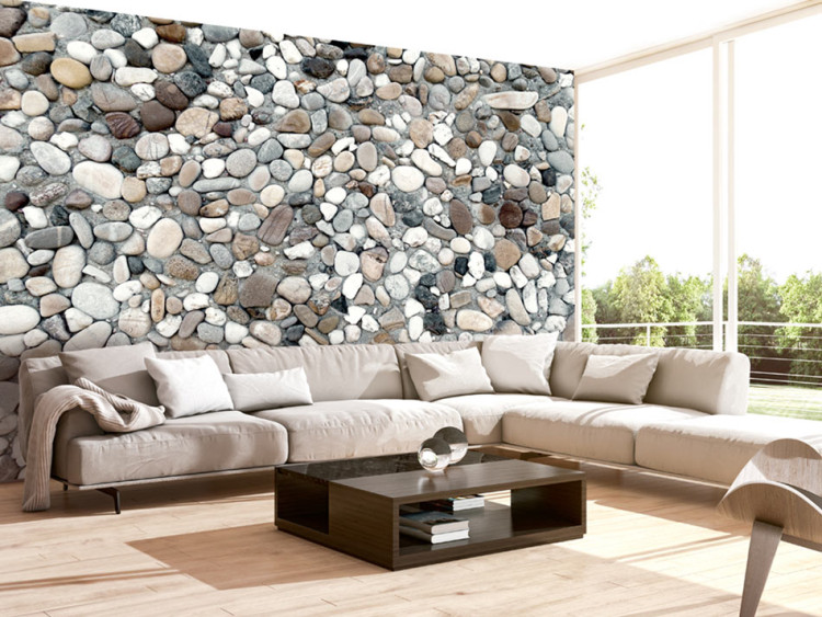 Fototapet Grå stenstrand - bakgrund med enhetligt mönster av olika stenar på sanden 64842